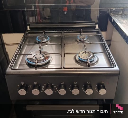 תנור וכיריים גז שחורים מחוברים ופועלים עם להבות גז כחולות